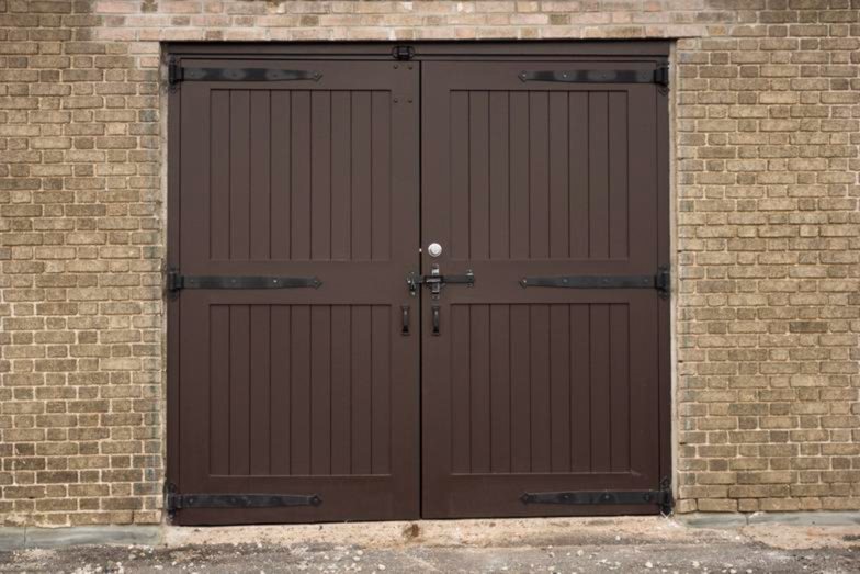 Pair of dark-stained wood carriage doors set into a stone wall