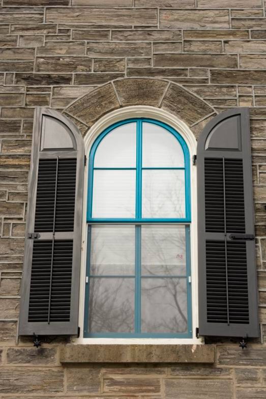 Gothic head window with arched sash in a stone facade