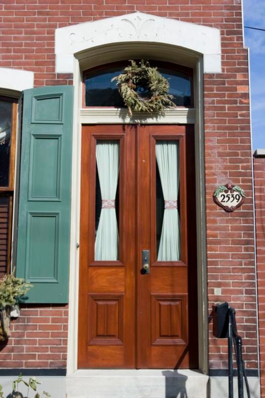 Arched double wood entry door on a red-brick Philadelphia rowhome