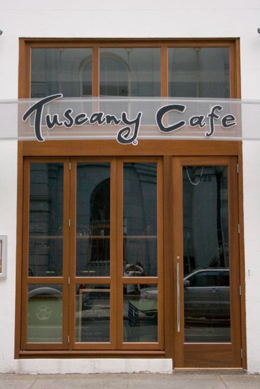 Wood storefront with divided-lite doors and transom at Tuscany Cafe